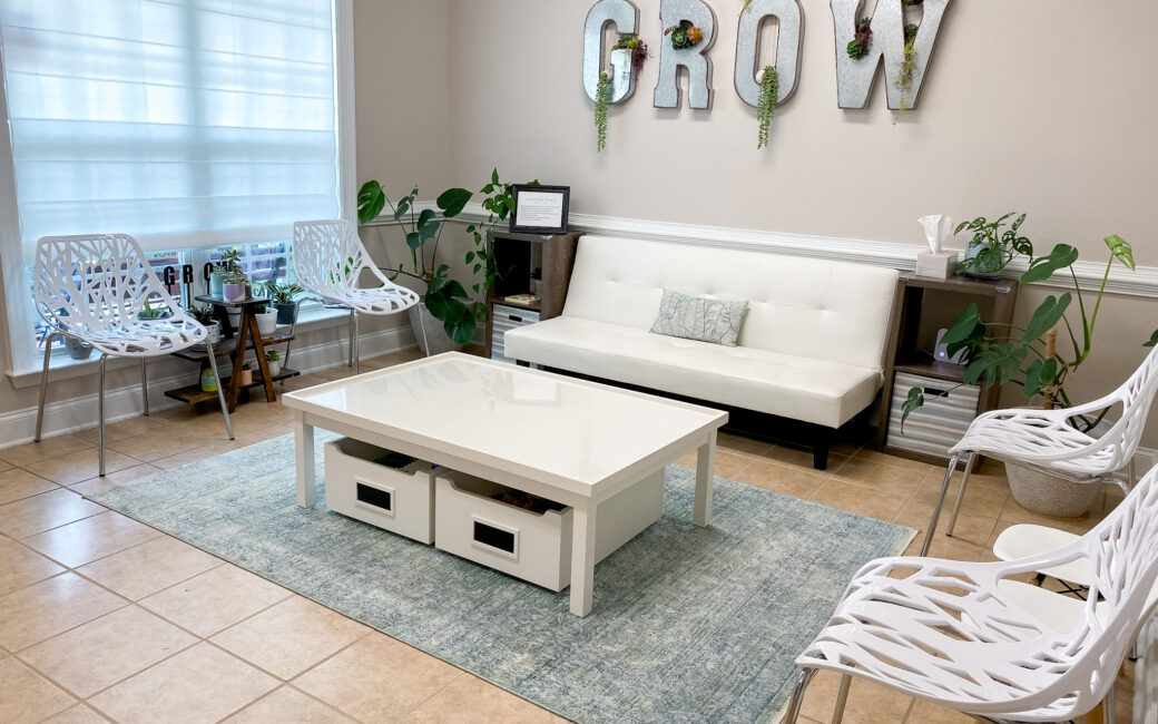 waiting room with white furniture and plants
