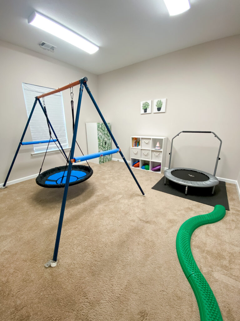 Motor room with swing, trampoline, and balance beam