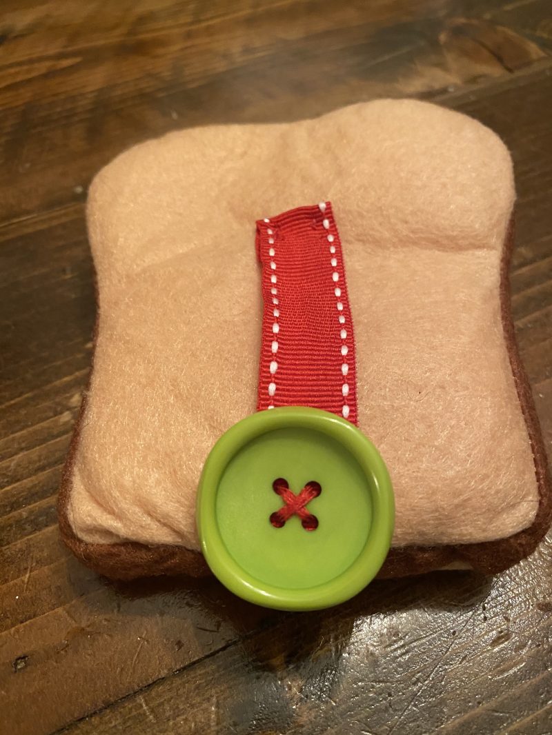 Felt sandwich bread with ribbon and large button sewn to center
